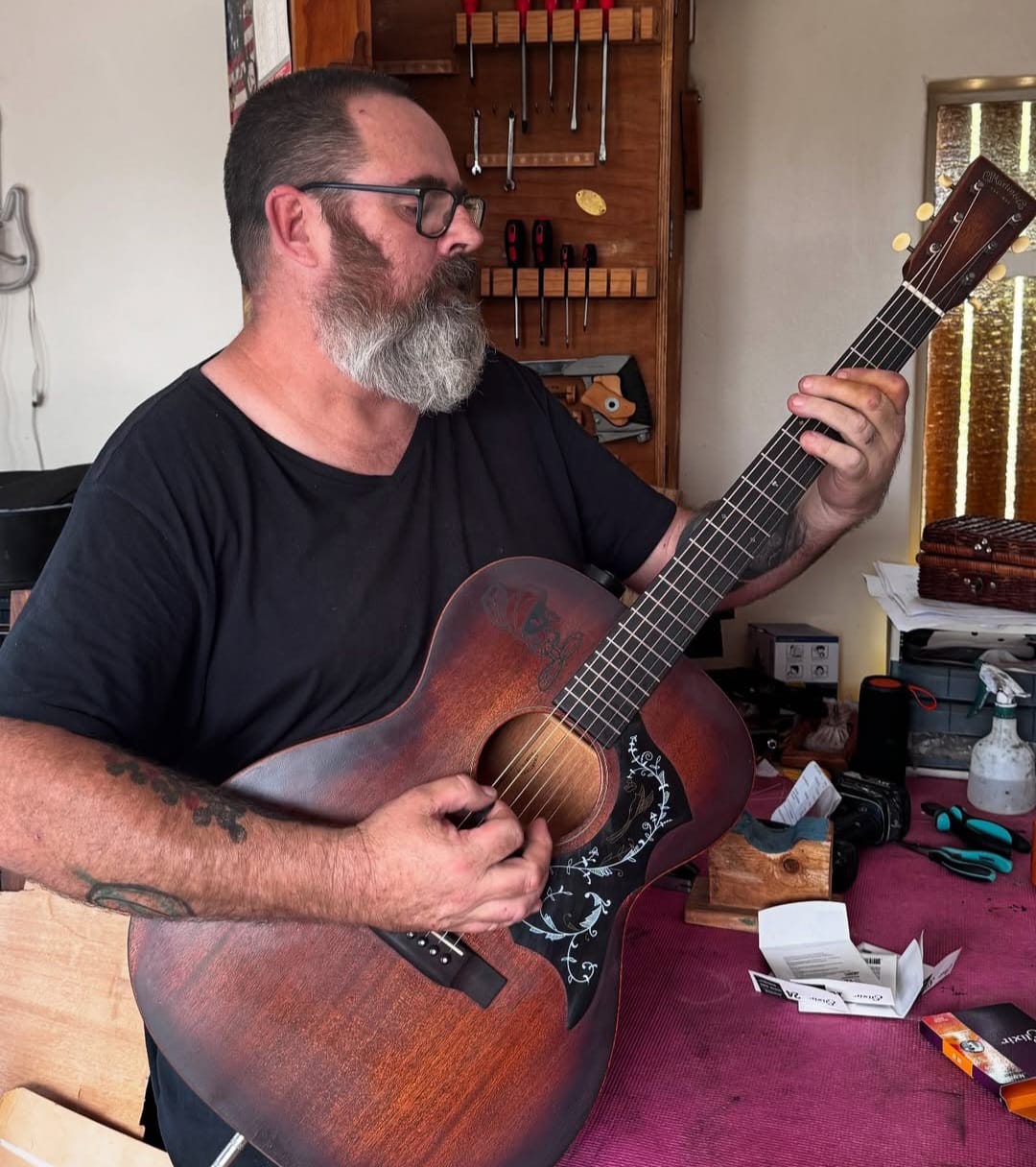 Steven playing guitar in his workshop
